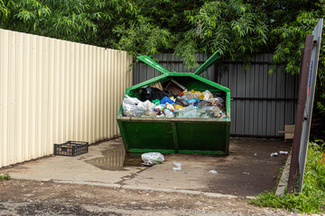 Green overflowing trash container