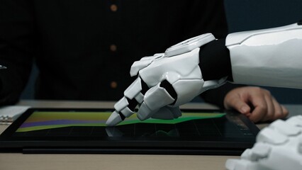 A close-up of a robotic hand interacting with a digital screen, showcasing data trends in a modern...