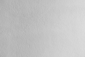 A close-up view of a rough white plaster wall texture, showing its subtle patterns and natural imperfections, perfect for background or design inspiration.