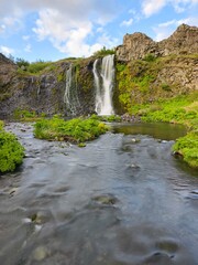 Waterfalls cascade in a green valley in Iceland