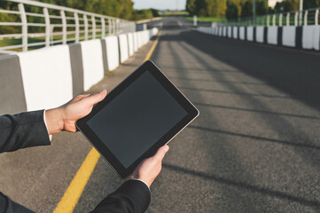 Businessperson Holding Tablet on Bridge Over Road