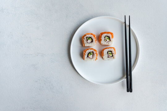 California roll with salmon on white ceramic plate