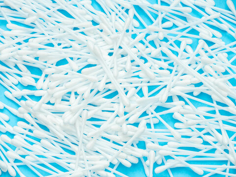 White Cotton Swabs Scattered on Blue Background
