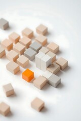 A collection of small, pastelcolored blocks forms an abstract pattern, with a single vibrant orange block standing out against the muted tones