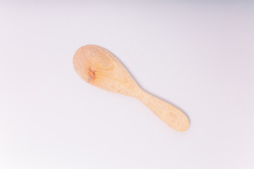 Top view of a wooden rice paddle (or rice spoon) placed on a clean white background. This kitchen utensil features a broad, flat surface and a short handle, ideal for scooping and serving rice.