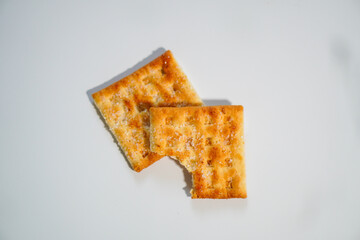 Two wheat biscuits with one half eaten on a white background