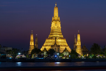 Naklejka premium Wat Arun Ratchawararam Ratchawaramahawihan or Wat Arun (Temple of Dawn) is a Buddhist temple along the Chao Phraya river at twilight in Bangkok, Thailand.