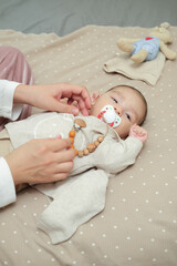 Infant baby asian boy is lying on the bed with pacifier.