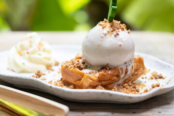 Delicious dessert featuring pastry with ice cream, topped with crumbs and served with whipped cream. Perfect for any sweet tooth.
