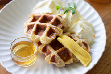 Delicious waffles served with cream and a drizzle of syrup, perfect for breakfast or dessert.