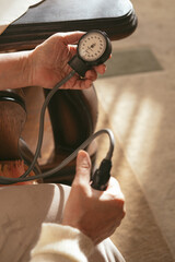 Senior woman with hypertension measuring blood pressure herself at home. Elder 70s lady measure...