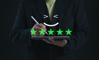 Businessman using a digital pen to mark a five-star rating on a tablet screen with a smiling face...