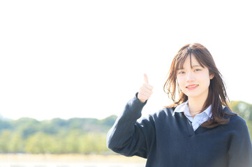 カメラ目線でグッドポーズをする日本人女子高生