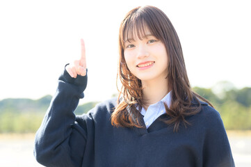 指を刺して微笑む日本人女子高生