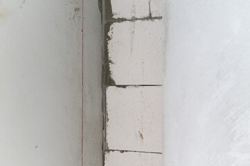 Close up of new wall during house renovation. Building with aerated concrete block and cement shows construction process and interior improvement project in progress