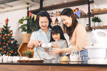 Grandmother cooking with daughter and mother family fun at home kitchen