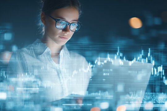 Woman with glasses working on laptop with financial data overlayed on screen.