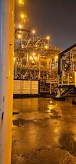 Industrial Facility at Night with Wet Ground Reflection
