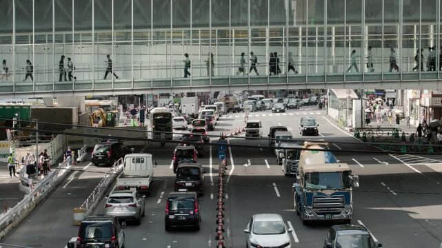 Tokyo Scene : Layers of the City. People Walking Quickly Along a Pedestrian Skyway Over a Busy Highway in a Entertainment District  |  Shibuya Station Area, Tokyo, Japan