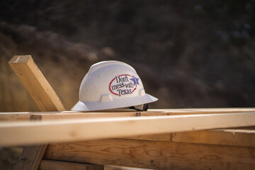Don't Mess With Texas Sticker on Hard Hat Sitting On Wooden Boards at Construction Site