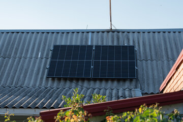 Solar panels installed on a rustic roof in a sunny environment, showcasing renewable energy...