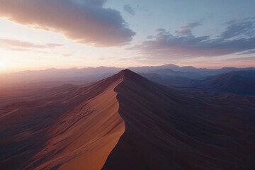 Naklejka premium Expansive sand dunes under golden hour light create stunning shadows