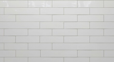 White rectangular ceramic tiles with grey grout lines arranged in a staggered pattern displaying a glossy finish