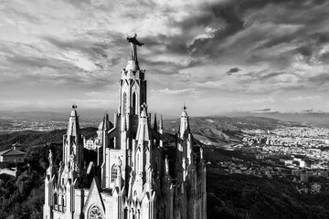 An aerial view capturing the iconic Sagrat Cor church atop Mount Tibidabo, with its grand...