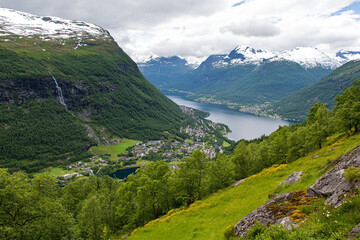 Naklejka premium Fjord with steep cliffs and cascading waterfalls in scenic landscape