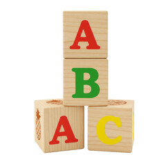 Natural wooden alphabet blocks featuring red 'A', green 'B' with pineapple carving, and yellow 'C' in a pyramid stack on a transparent studio background with shadowless lighting, educational toy