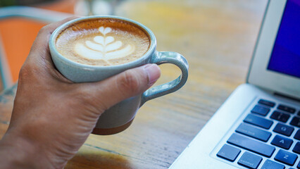 Holding a cup of coffee with latte art