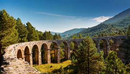 Obraz premium historic stone aqueduct in scenic mountain landscape with pine trees