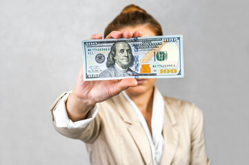 Hand Holding One Hundred Dollar Bill: Symbol of Wealth