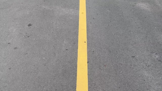 Footage of a walk along a yellow lane divider.