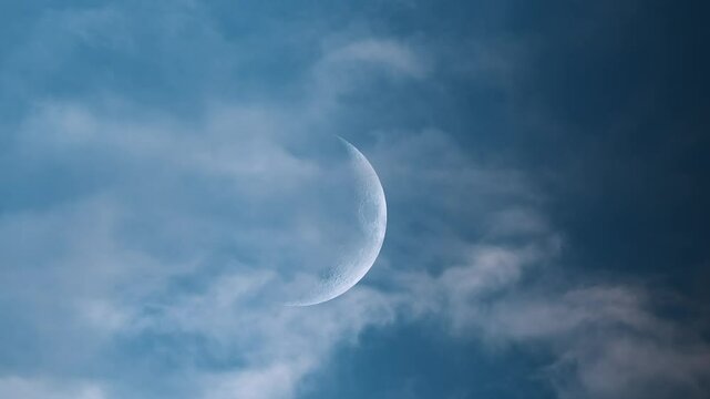 Real-time video of a crescent moon drifting across the sky with fast-moving clouds. A tranquil celestial scene ideal for themes of nature, weather, astronomy, or dreamlike motion.