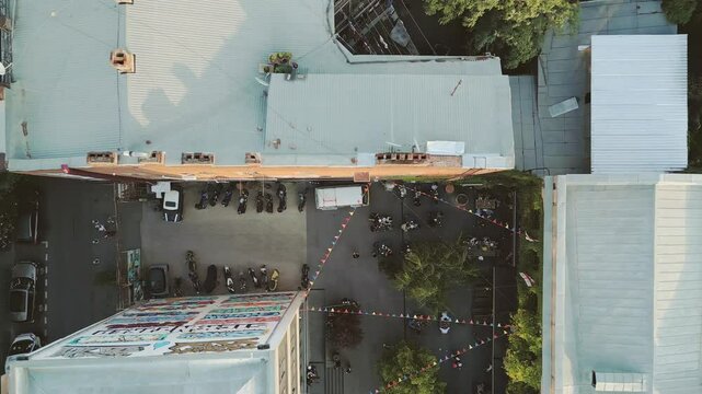 Tbilisi, Georgia - 1st july, 2025: Aerial Fabrika courtyard in Tbilisi, vibrant social hub with outdoor seating, trees, string lights, groups of guests enjoying the lively atmosphere in heart of city