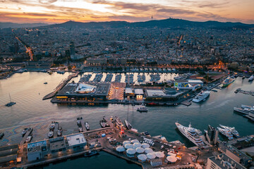Barcelona Marina: Luxury Yachts and City Lights at Twilight

An aerial view of Barcelona's bustling marina at twilight, showcasing numerous luxury yachts, illuminated docks, and the city skyline in th