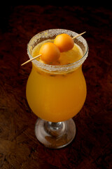Tropical Passion Fruit Margarita cocktail with a sugar rim and goldenberry garnish, a refreshing...