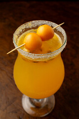 Tropical Passion Fruit Margarita cocktail with a sugar rim and goldenberry garnish, a refreshing...