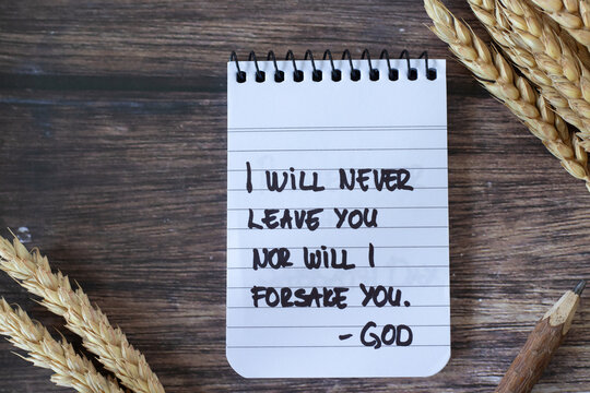 I will never leave you nor will I forsake you-God, handwritten verse in notebook and ripe wheat on wooden background. Inspirational Christian quote, biblical concept.