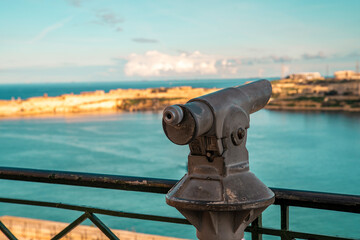 Tourist using a telescope to enjoy Malta’s scenic views

