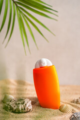 Sunblock or sunscreen in cosmetic tube on beach sand and beige background. Summer vacation and skin care concept with starfish and sea shells, spf uv-protect cosmetics. Skin health. High quality photo