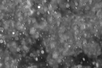 Falling raindrops  background with backlight and bokeh for graphic overlay effect.