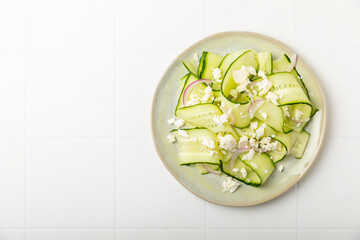 Cucumber salad on a wooden background.Homemade salad with fresh vegetables, cucumber, tomato, sweet...