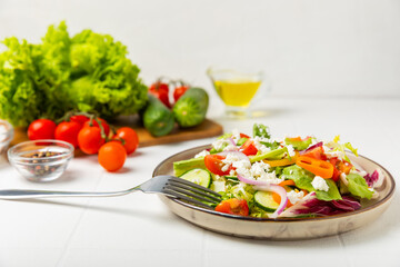 Cucumber salad on a wooden background.Homemade salad with fresh vegetables, cucumber, tomato, sweet...