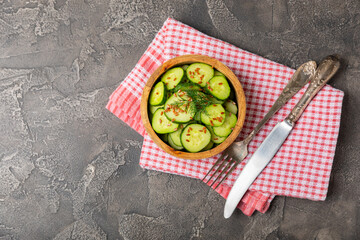 Cucumber salad on a wooden background.Homemade salad with fresh vegetables, cucumber, tomato, sweet...
