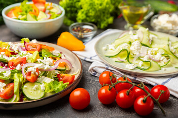 Cucumber salad on a wooden background.Homemade salad with fresh vegetables, cucumber, tomato, sweet...
