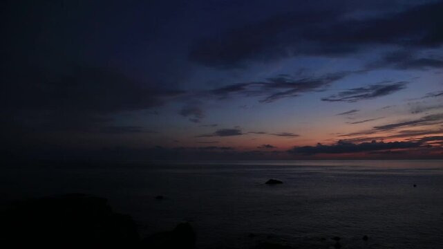 奄美大島の夏のの日の出前の島影と海。