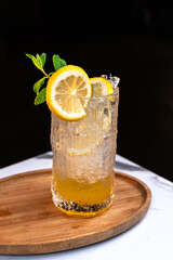 Iced Lemon Drink in Textured Glass with Citrus Garnish on Wooden Tray