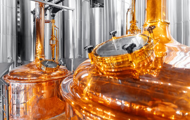 Modern brewery factory with shiny copper fermentation tanks and industrial equipment